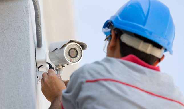 Top Tips for Achieving Flawless Security Solutions A technician installing a security camera on a wall, ensuring proper setup and functionality