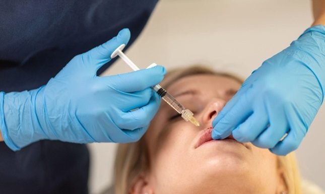 How Dermal Fillers Are Revolutionizing Beauty Treatments in Calgary A professional administering lip filler to the customer