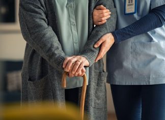Financial Planning for Long-Term Home Care Support Caregiver supporting an elderly person with a cane
